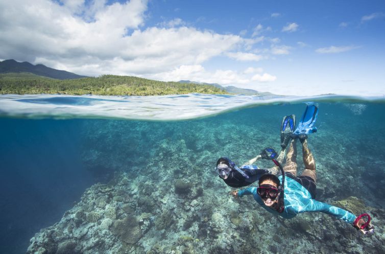 Underwater reef landscape and snorkellers, near Mystery Island,
